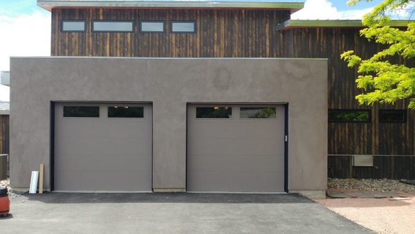 Twin taupe garage doors on stucco facade