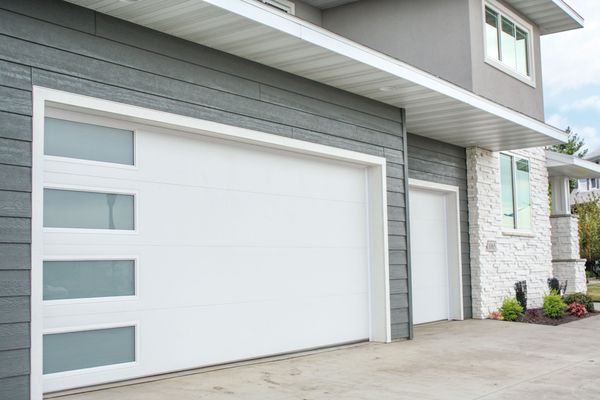 Modern white sectional garage door with vertical glass panels